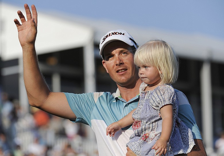 Henrik Stenson celebrates with his daughter, Lisa, leaving the 18th green after winning the Players Championship.