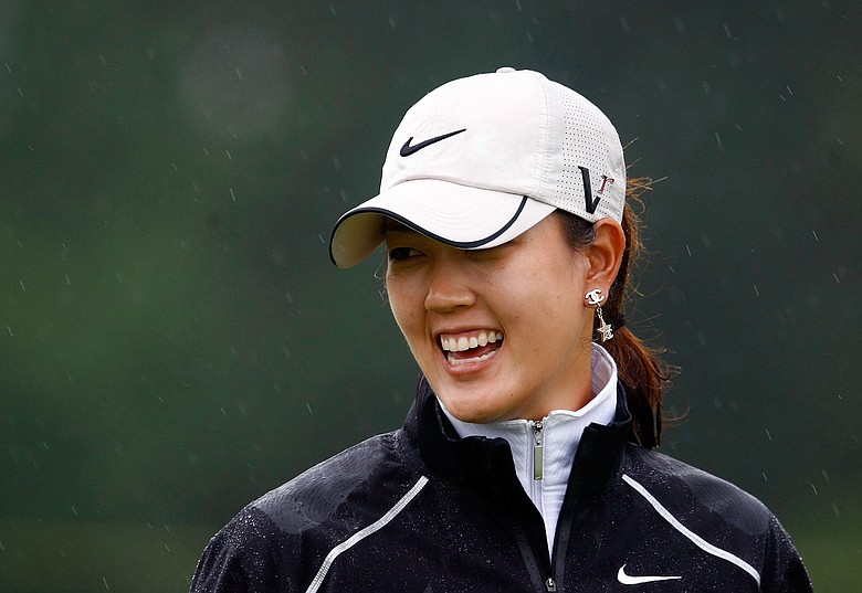 Michelle Wie waits in the rain on the practice green during the first round of the McDonald's LPGA Championship.