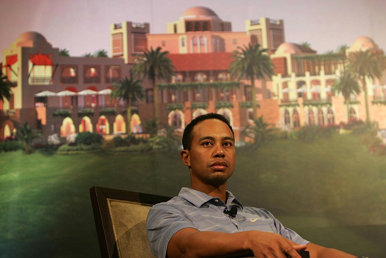 Tiger Woods in front of a poster showing the planned development of the Tiger Woods Dubai community at a venue in Dubai.