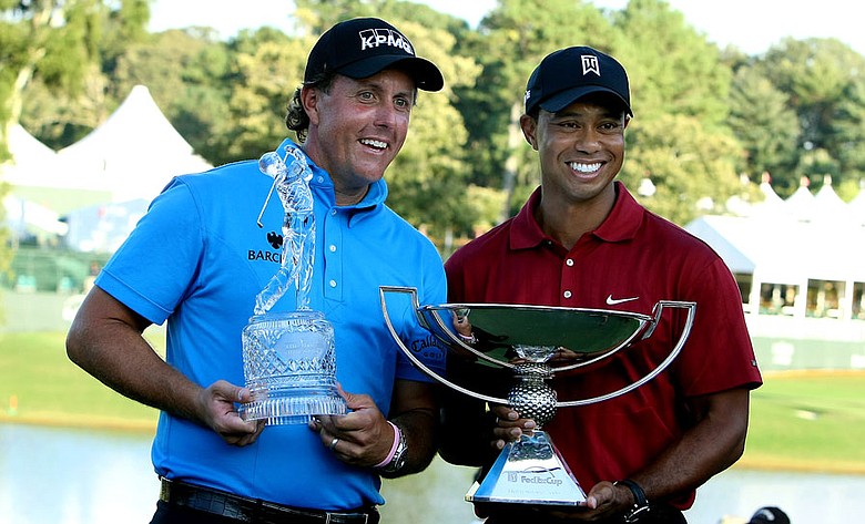 Phil Mickelson and Tiger Woods pose with their prizes.