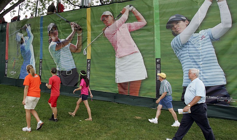 Fans walk past posters of Natalie Gulbis, Lorena Ochoa, Paula Creamer and Juli Inkster at an LPGA event. The tour plans to showcase its top stars at a new tournament this fall in Malaysia.