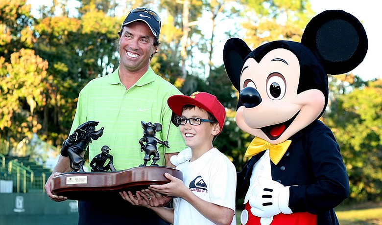 Stephen Ames holds the championship trophy with son, Ryan, 10, and Mickey Mouse after winning the Children's Miracle Network Classic on Nov. 15.