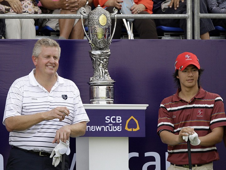 Colin Montgomerie, left, and Ryo Ishikawa stand beside Royal Trophy before facing off in their opening foursomes match.