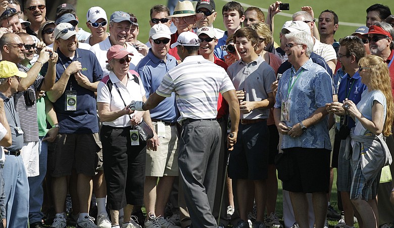 Tiger Woods hands a ball to a fan Monday at Augusta.