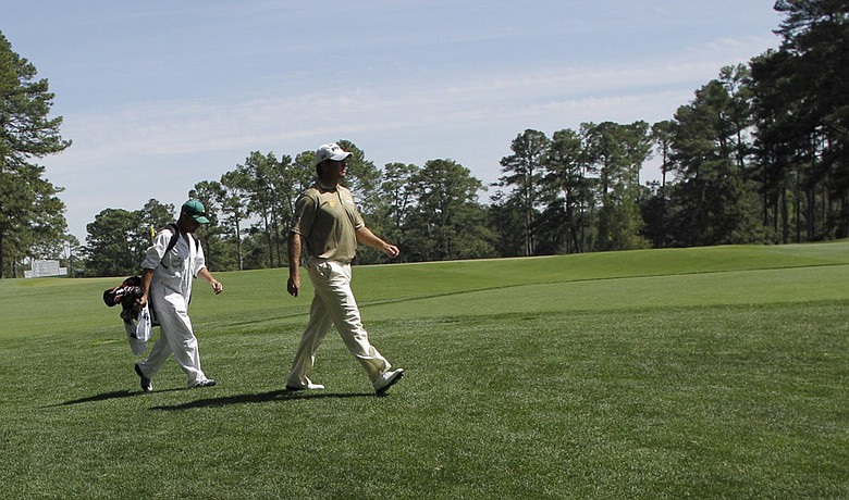Lee Westwood walks down the fourth fairway with his caddie Billy Foster during the third round of the Masters.