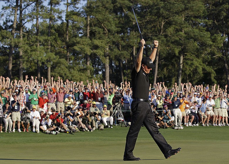 Phil Mickelson celebrates on the 18th green after making birdie and winning his third Masters by three shots.