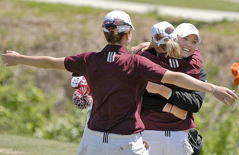 Texas A&M junior Sarah Zwartynski is hugged by her teammates after sinking the putt to win the Big 12 Championship.