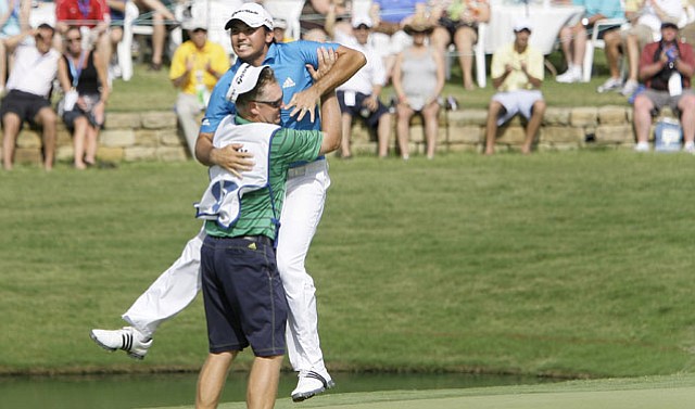 Jason Day of Australia leaps into the arms of his caddie Colin Swatton after winning the 2010 Byron Nelson Championship tournament.
