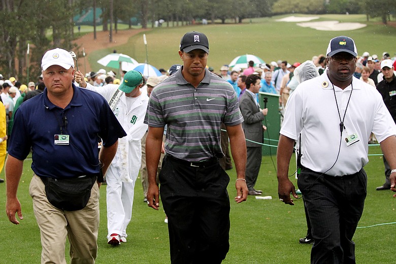 Tiger Woods walks with security during the first round of the 2010 Masters.