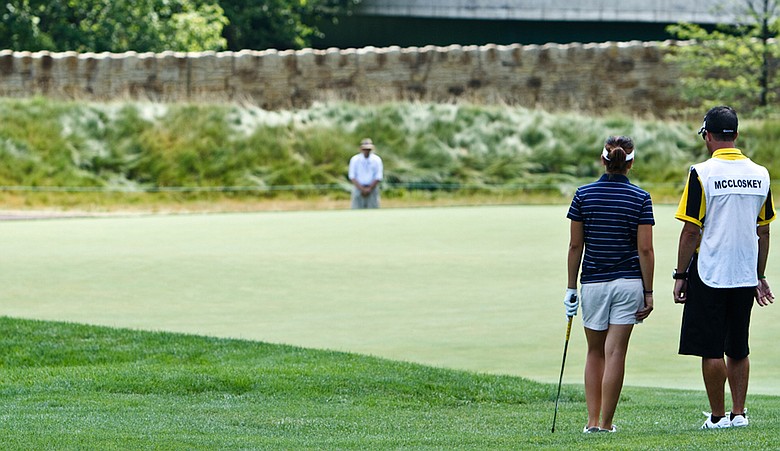 Lisa McCloskey and her caddie wait on the first hole Saturday at Oakmont.