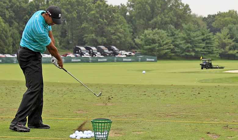 Tiger Woods hits balls on the practice range at the Bridgestone Invitational.