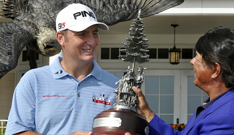 Bill Lunde, left, receives the trophy from Ray Halbritter, CEO of Turning Stone Resort, after winning the Turning Stone Resort Championship.
