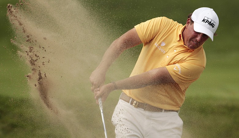 Phil Mickelson blasts out of a bunker on the 15th hole at Whistling Straits.