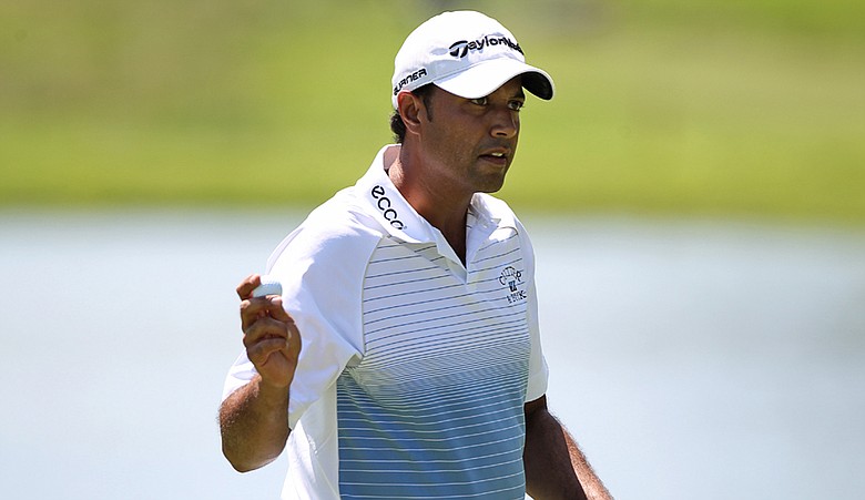 Arjun Atwal waves to the crowd after making birdie on the 15th hole during the second round of the Wyndham Championship.