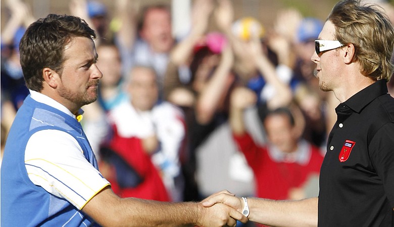 Graeme McDowell and Hunter Mahan shake hands at the conclusion of their Ryder Cup singles match.