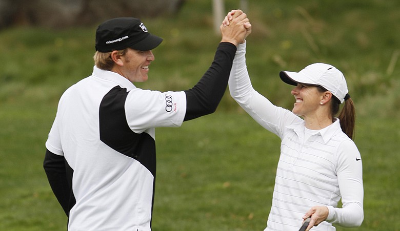 Ricky Barnes high-fives former soccer player Brandi Chastain during the 2010 AT&T Pebble Beach National Pro-Am.