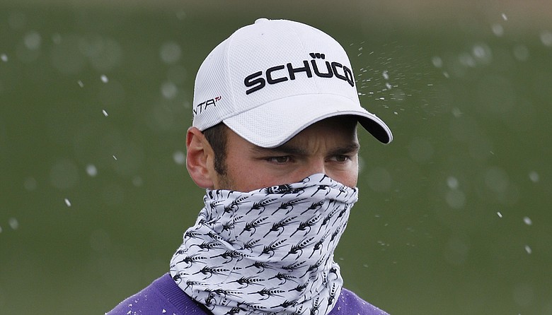 Martin Kaymer of Germany pulls his buff over his face as snow falls while playing Luke Donald of England in the finals of the Match Play Championship golf tournament Sunday, Feb. 27, 2011, in Marana, Ariz.