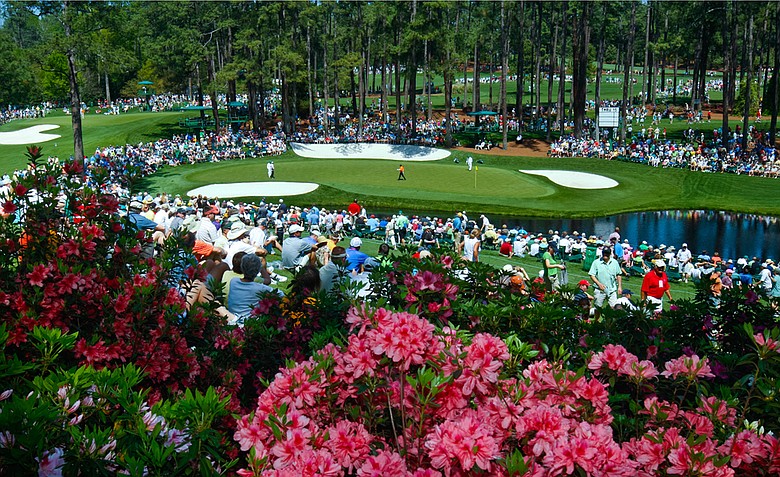 Fans wait around the par-3 16th hole at Augusta National during Monday's practice round.