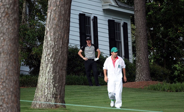Rory McIlroy of Northern Ireland waits to plays a shot on the tenth hole as his caddie J.P. Fitzgerald looks on during the final round of the 2011 Masters Tournament at Augusta National Golf Club on April 10, 2011 in Augusta, Georgia.