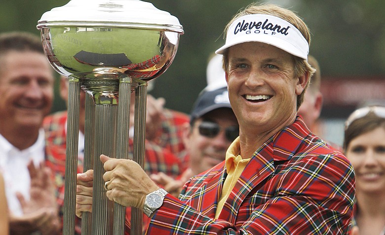 David Toms wears the winner's jacket and holds up the Colonial trophy after winning the golf tournament in Fort Worth, Texas, Sunday, May 22, 2011.