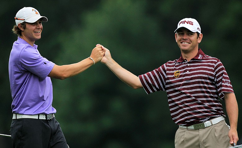 Louis Oosthuizen, right, fist-bumps Peter Uihlein after Uihlein holed out for eagle on the fifth hole Thursday at Congressional.