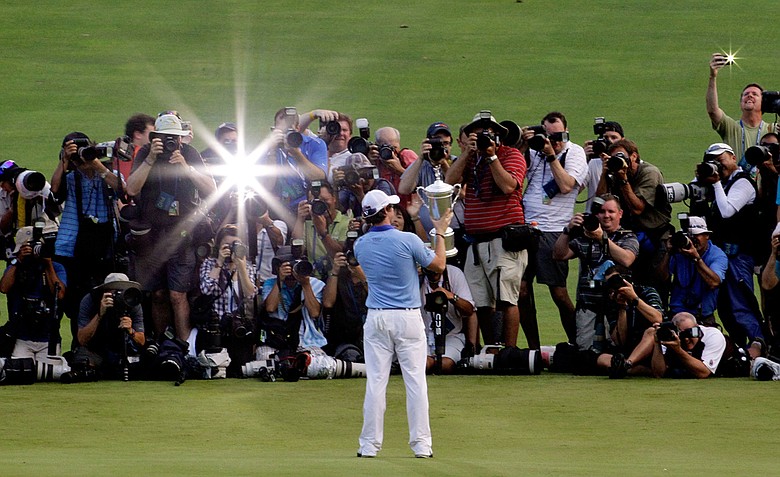 Rory McIlroy of Northern Ireland poses with the trophy for photographers after his eight-stroke victory on the 18th green during the 111th U.S. Open at Congressional Country Club on June 19, 2011 in Bethesda, Maryland.