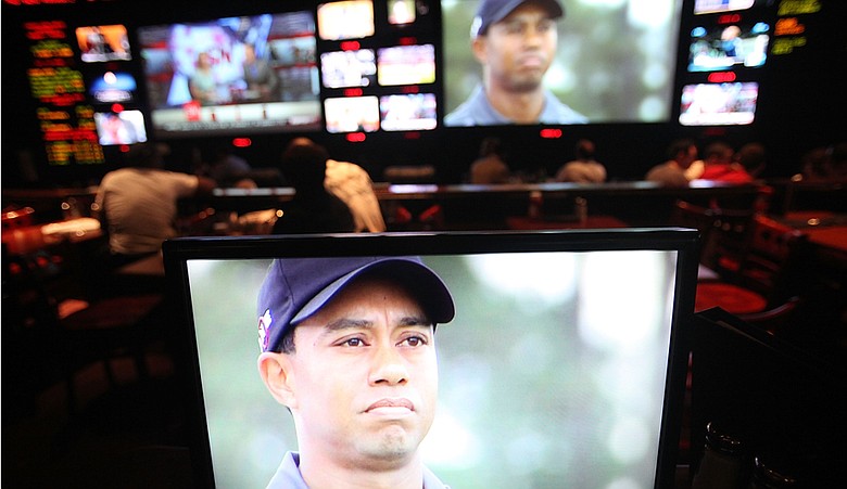 Sports fans watch Tiger Woods play during Masters coverage televised at ESPN Zone in New York City.