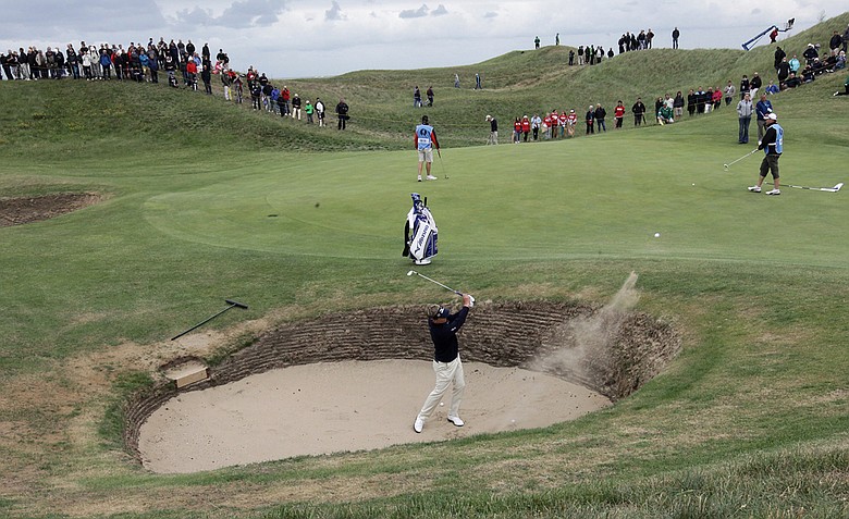 England's Luke Donald hits a ball out of the bunker onto the 6th green during a practice round ahead of the British Open Golf Championship at Royal St George's golf course in Sandwich, England, Wednesday, July 13, 2011.