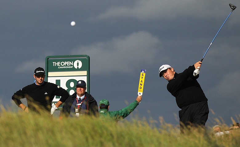 South Africa's George Coetzee plays a shot off the 18th tee as Dustin Johnson of the US, left, looks on during the third day of the British Open Golf Championship at Royal St George's golf course Sandwich, England, Saturday, July 16, 2011.