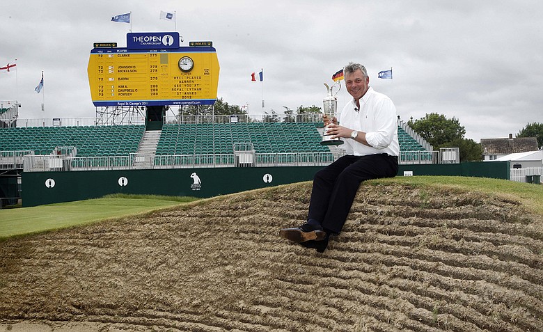 Northern Ireland's Darren Clarke holds the Claret Jug troffy beside the 18th green after he won the Open Golf Championship on Sunday, at Royal St George's Sandwich, England, Monday, July, 18, 2011.