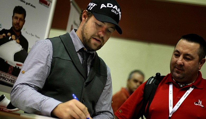 Ryan Moore signs an autograph while at the TRUE Linkswear booth during the PGA Merchandise Show. (file photo)