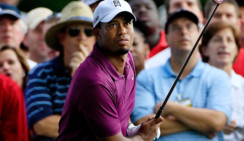 Tiger Woods hits a shot from the rough on the 16th hole during the first round of the World Golf Championships-Bridgestone Invitational on the South Course at Firestone Country Club.