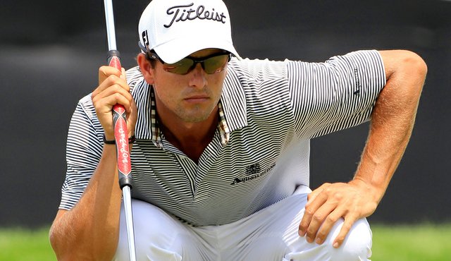 Adam Scott lines up his putt on the 18th hole during the third round ...