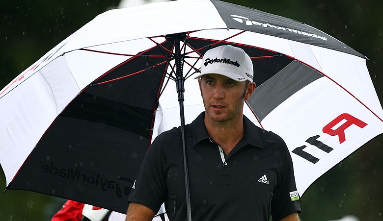 Dustin Johnson stands under an umbrella on the eighth tee box during the third and final round of The Barclays at Plainfield Country Club. Johnson won the event, which was shortened due to Hurricane Irene.
