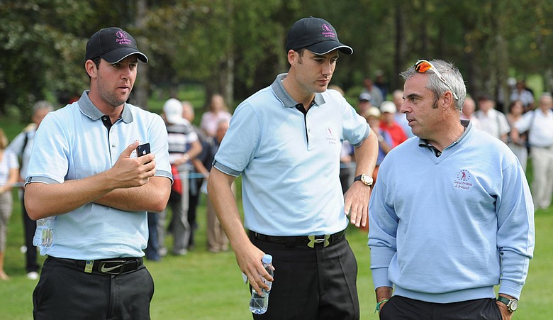 Scott Jamieson, left, and Ross Fisher of the Great Britain and Ireland team talk with captain Paul McGinley during the first day's fourball matches at the Vivendi Seve Trophy.