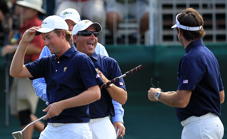 U.S. captain Fred Couples, center, celebrates with Webb Simpson, left and Bubba Watson of the U.S. team on the 16th green during the Day One Foursome matches.