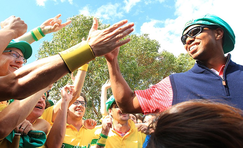 Tiger Woods of the U.S. celebrates with Aussie fans on the 17th hole after the Day Four singles matches of the 2011 Presidents Cup.