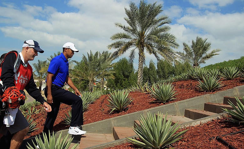 Tiger Woods of the USA walks to a tee with his caddie Joe Lacava during the pro-am event prior to the start of the Abu Dhabi HSBC Golf Championship at the Abu Dhabi Golf Club.