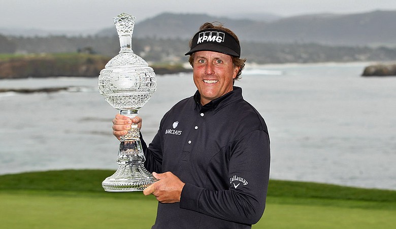 Phil Mickelson celebrates with the tournament trophy after winning with an eight-under-par 64 during the AT&T Pebble Beach National Pro-Am at Pebble Beach.