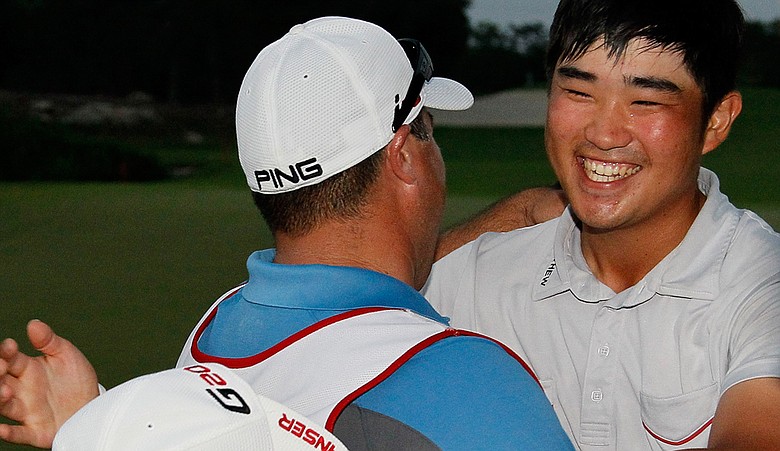 John Huh celebrates with his caddie Zeke Salas after winning the Mayakoba Golf Classic.