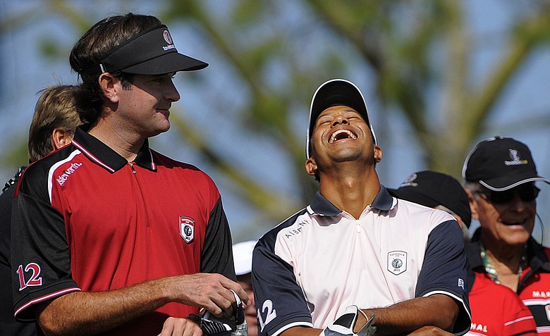 Team Isleworth's Bubba Watson, left, and Team Albany's Tiger Woods laugh at the announcer's joke as they wait to tee off at the first tee during the two-day Tavistock Cup.