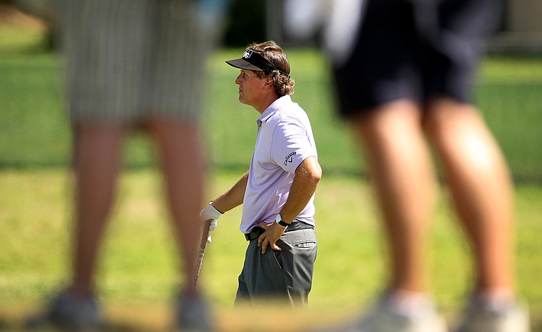 Phil MIckelson can be seen through the gallery's legs as he waits to hit at No. 4 during the first round.