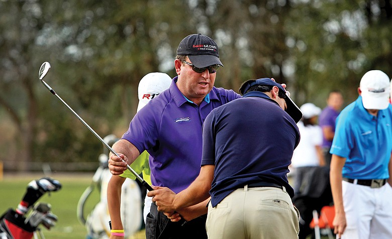 Gary Gilchrist works with a student on the range at Mission Inn in Howey-in-the-Hills, Fla., home of his own junior golf academy.