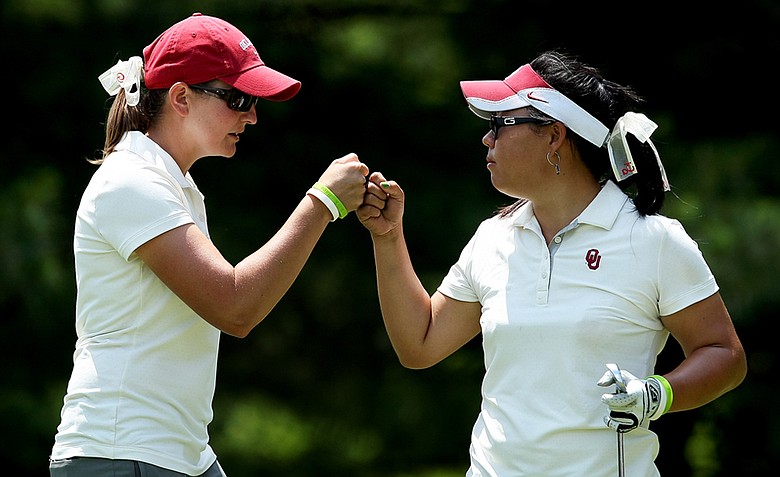 Oklahoma head coach, Veronique Drouin-Lutrell fist bumps with Chirapat Jao-Javanil at No. 16 on Thursday at the 2012 NCAA Division I Women's Golf Championships. Jao-Javanil shot a 70 in her third round.