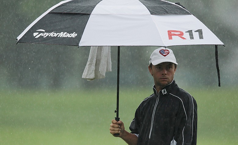 Spencer Levin waits under an umbrella on the seventh hole during the second round of the Memorial Tournament.