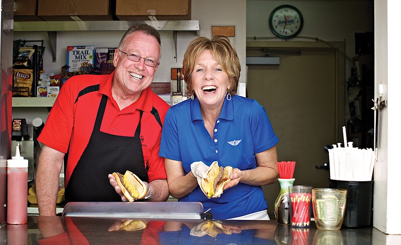 Steve Parrish (left) and Candy Parrish-Thrush serve up their famous burger dogs in much the same fashion as their father did 60 years ago.
