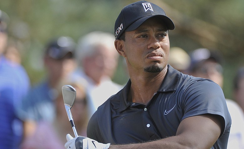 Tiger Woods stretches before hitting his tee shot on the 12th hole during the second round of the Bridgestone Invitational golf tournament at Firestone Country Club, Friday, Aug. 3, 2012, in Akron, Ohio.