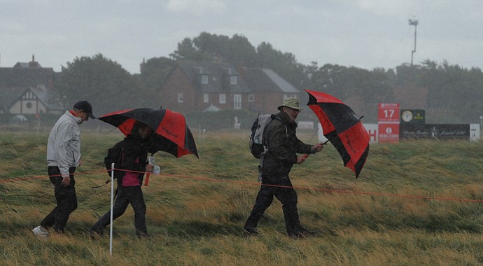 Spectators wait in bad weather for play to resume during the second round of the Women's British Open at the Royal Liverpool Golf Club in Hoylake, northern England.