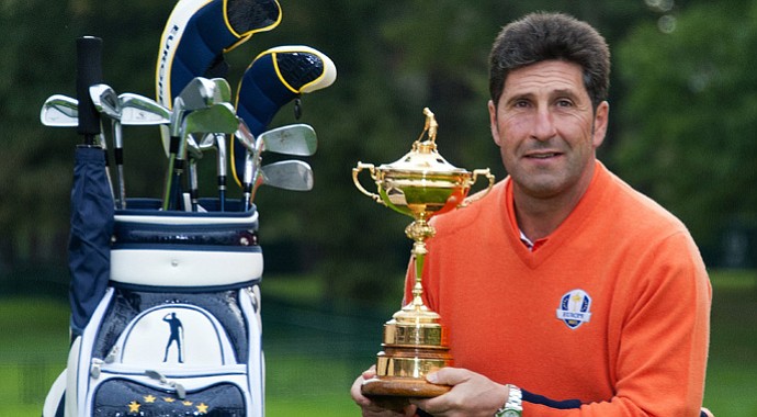 Jose Maria Olazabal poses with the Ryder Cup, as well as the stand bag with Seve Ballesteros' image on it.