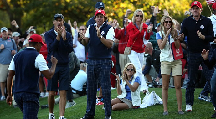 Tiger Woods of the USA passes Phil Mickelson and and Keegan Bradley after making birdie on the 16th hole.